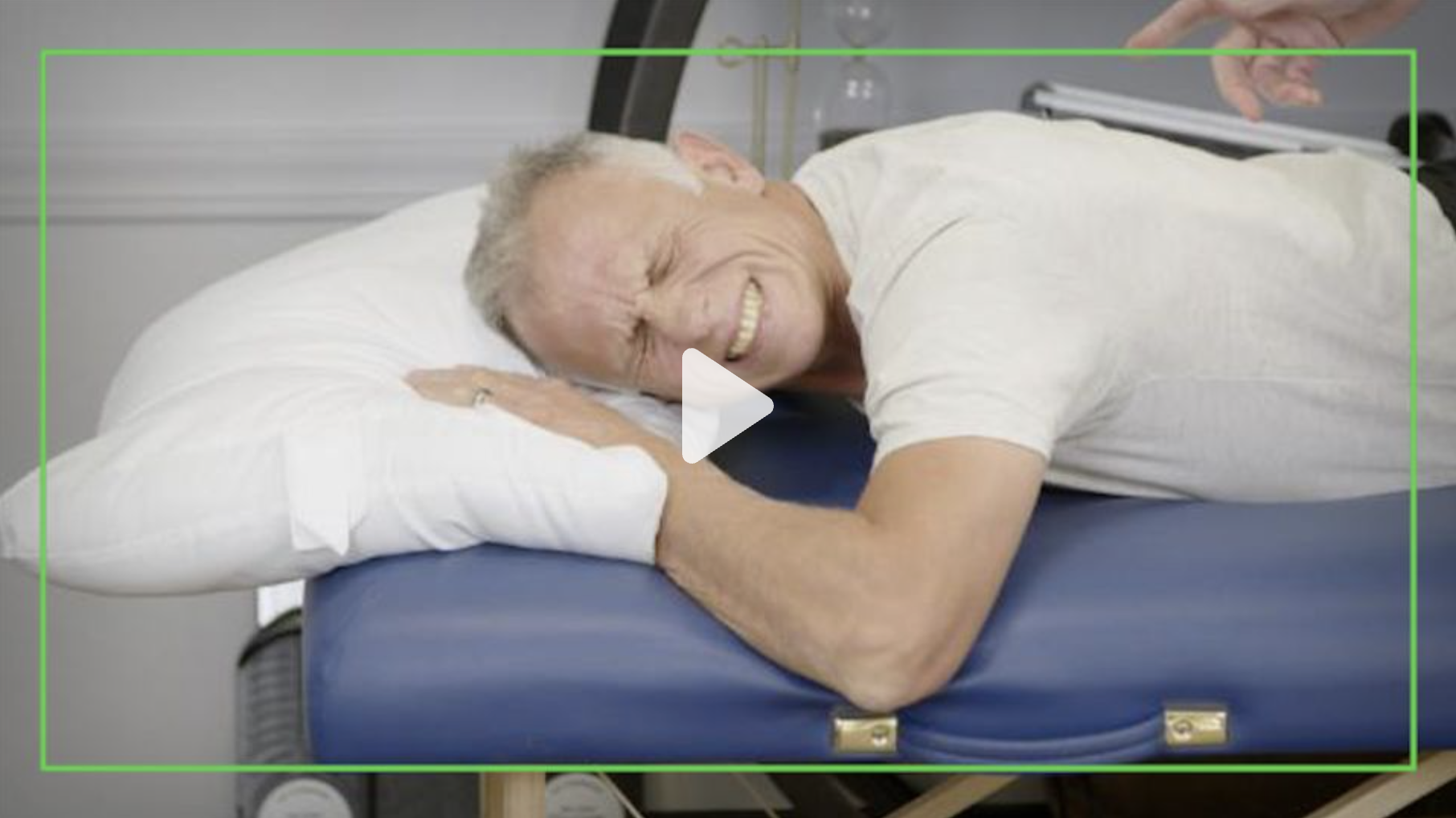 A physical therapist lies on his stomach in a demonstration