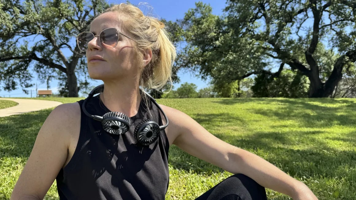 Person sitting outside wearing a neck fan