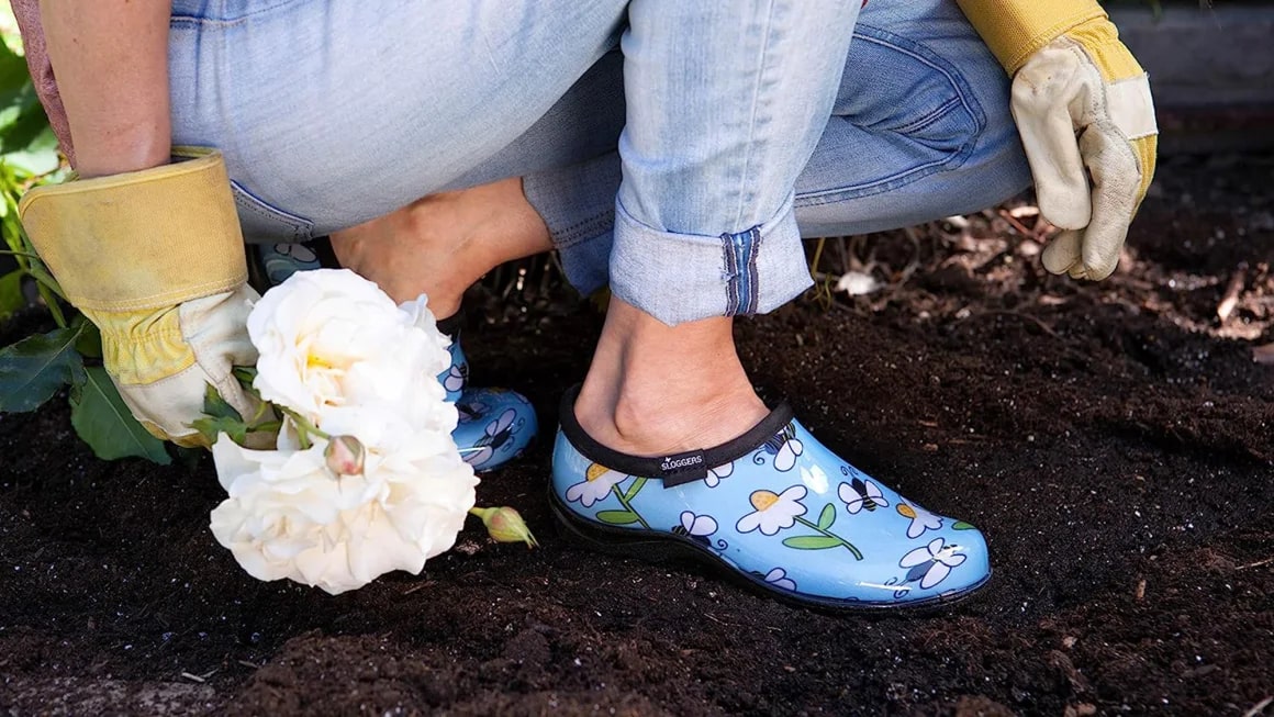 Person wearing blue gardening clogs