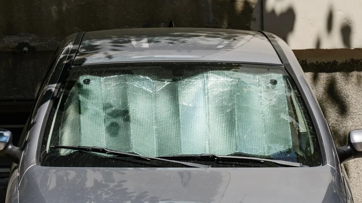 Car with silver sun shade in window