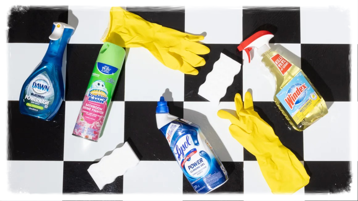 Variety of cleaning products on black and white checkered tile