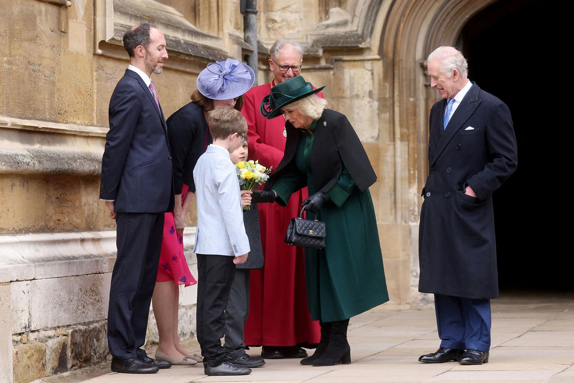 Queen Camilla is gifted a bouquet of flowers following the Easter service. 