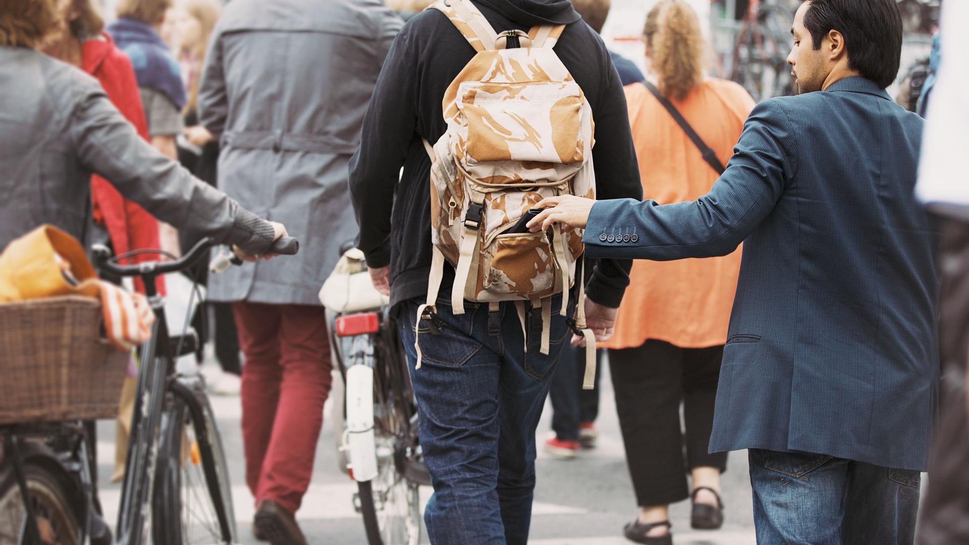 man stealing from a backpack