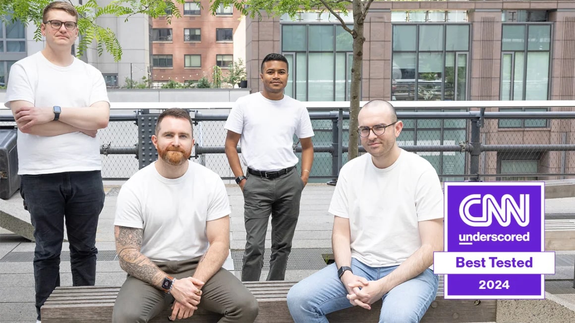 Four men wearing white T-shirts and pants.