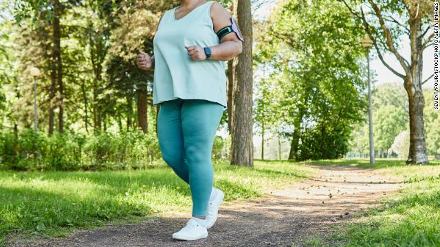 A woman walks outdoors in athletic clothing