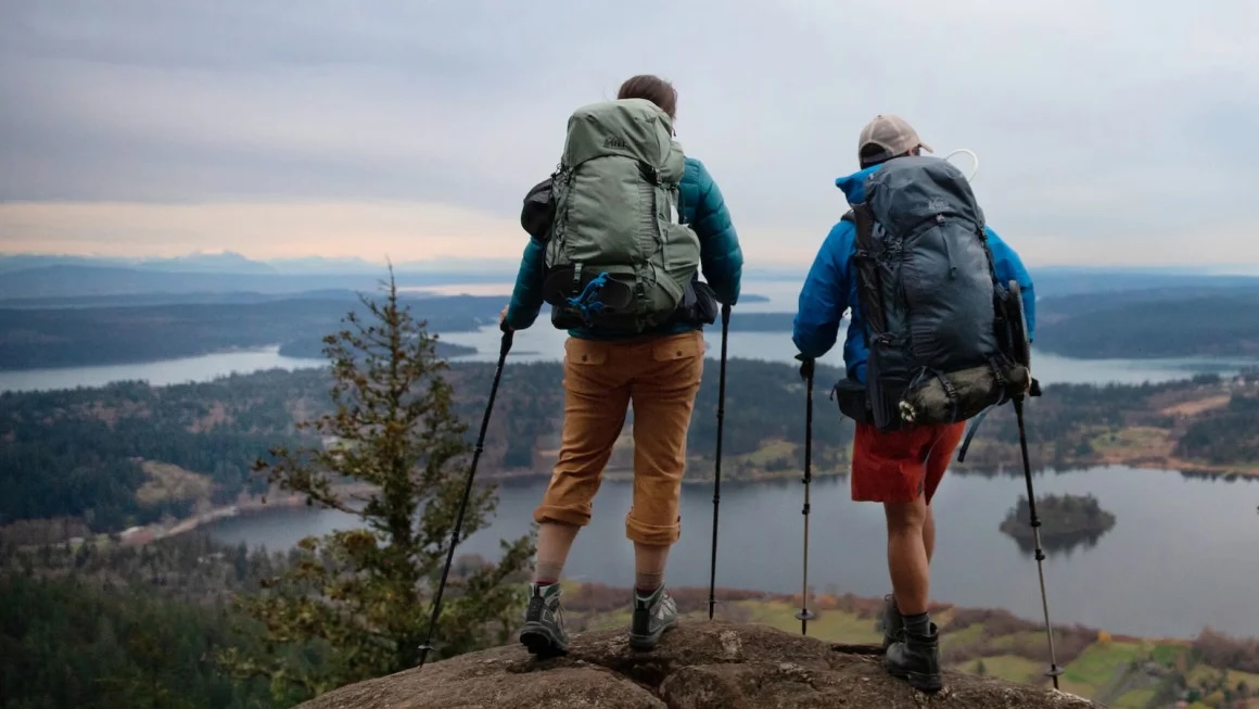 Two people overlooking a valley wearing hiking gear