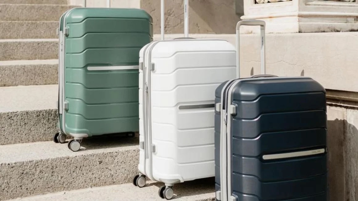 Green, white and navy Samsonite suitcases lined up outside