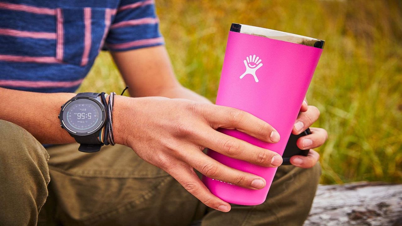 Person carrying a pink travel mug