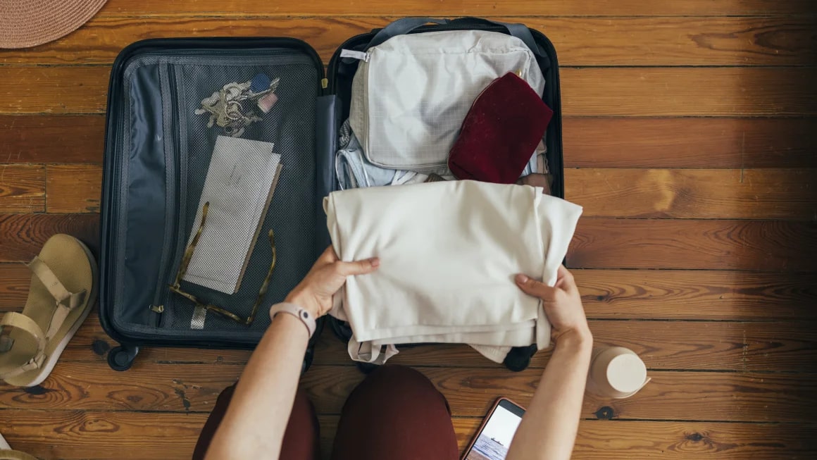 Person packing carry-on suitcase