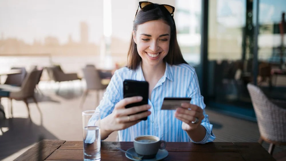 Woman holding a phone and credit cart