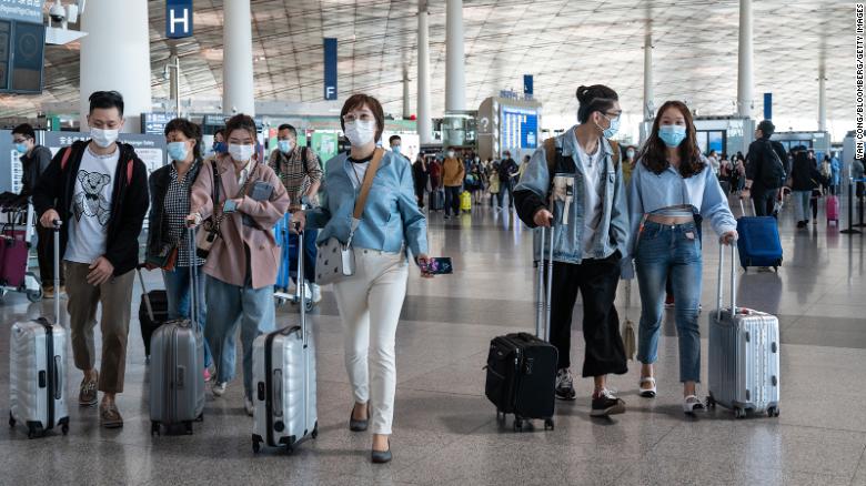 Travelers walk through Beijing Capital International Airport in Beijing, China, on Saturday, May 1, 2021.