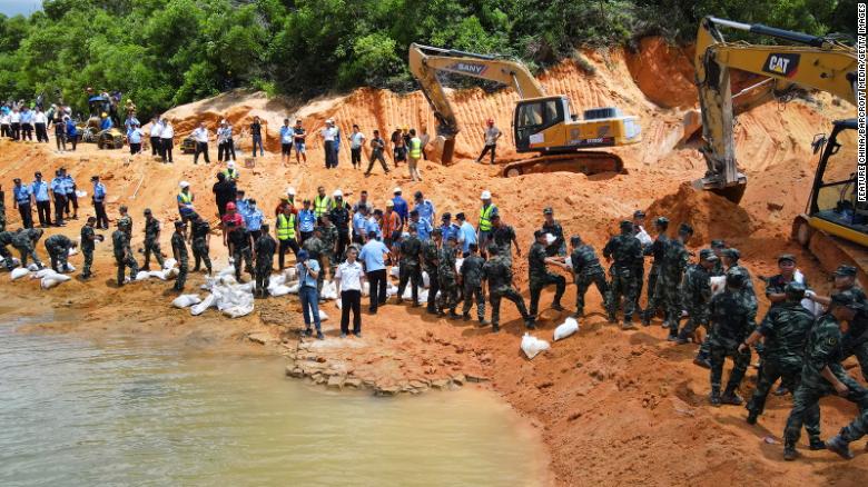 Rescuers pump out water from a flooded tunnel under construction in the city of Zhuhai in southern China. Fourteen workers have been trapped in the highway tunnel after it collapsed in the early hours of Thursday.