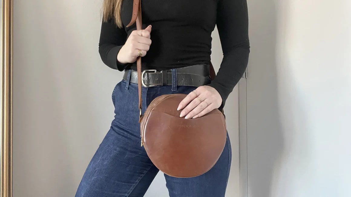 Close-up of woman holding brown round purse