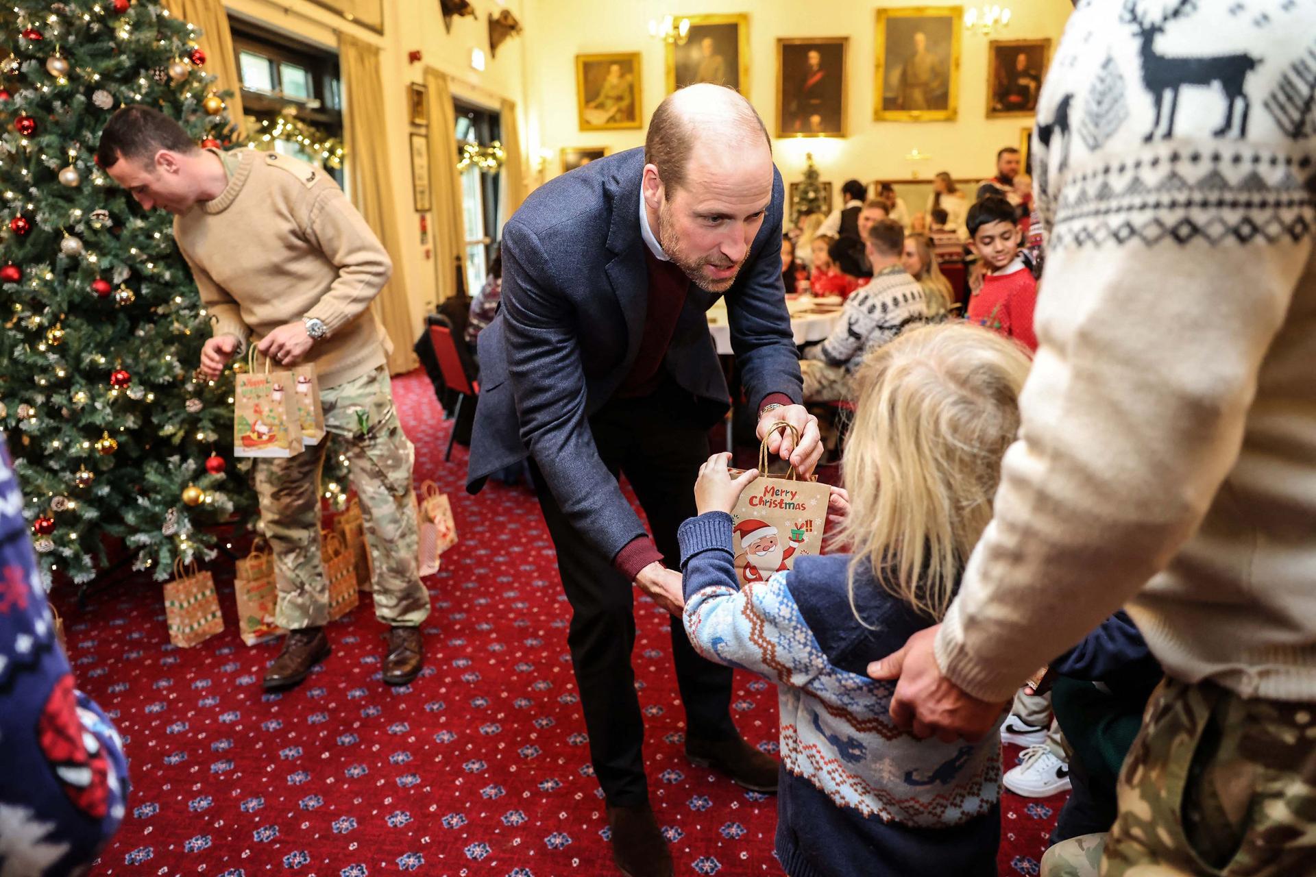 Prince William hands a gift to a child during his visit to the First Battalion Regiment at Picton Barracks in Bulford, southwest England on December 10th 2024.