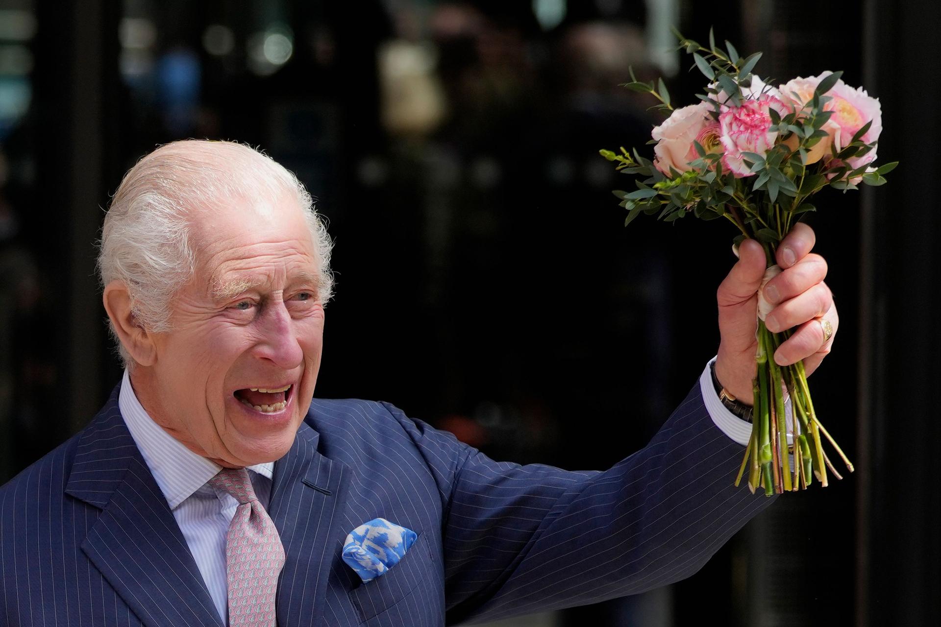 King Charles waves a bouquet in the air as he departs from the University College Hospital Macmillan Cancer Centre on April 30, 2024