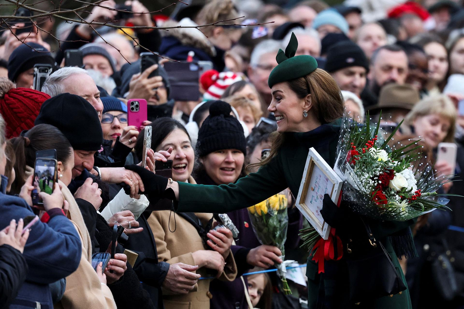 Catherine, Princess of Wales greets members of the public as the royal family make their way to St. Mary Magdalene's church on the Sandringham estate in eastern England for the traditional Christmas Day service.