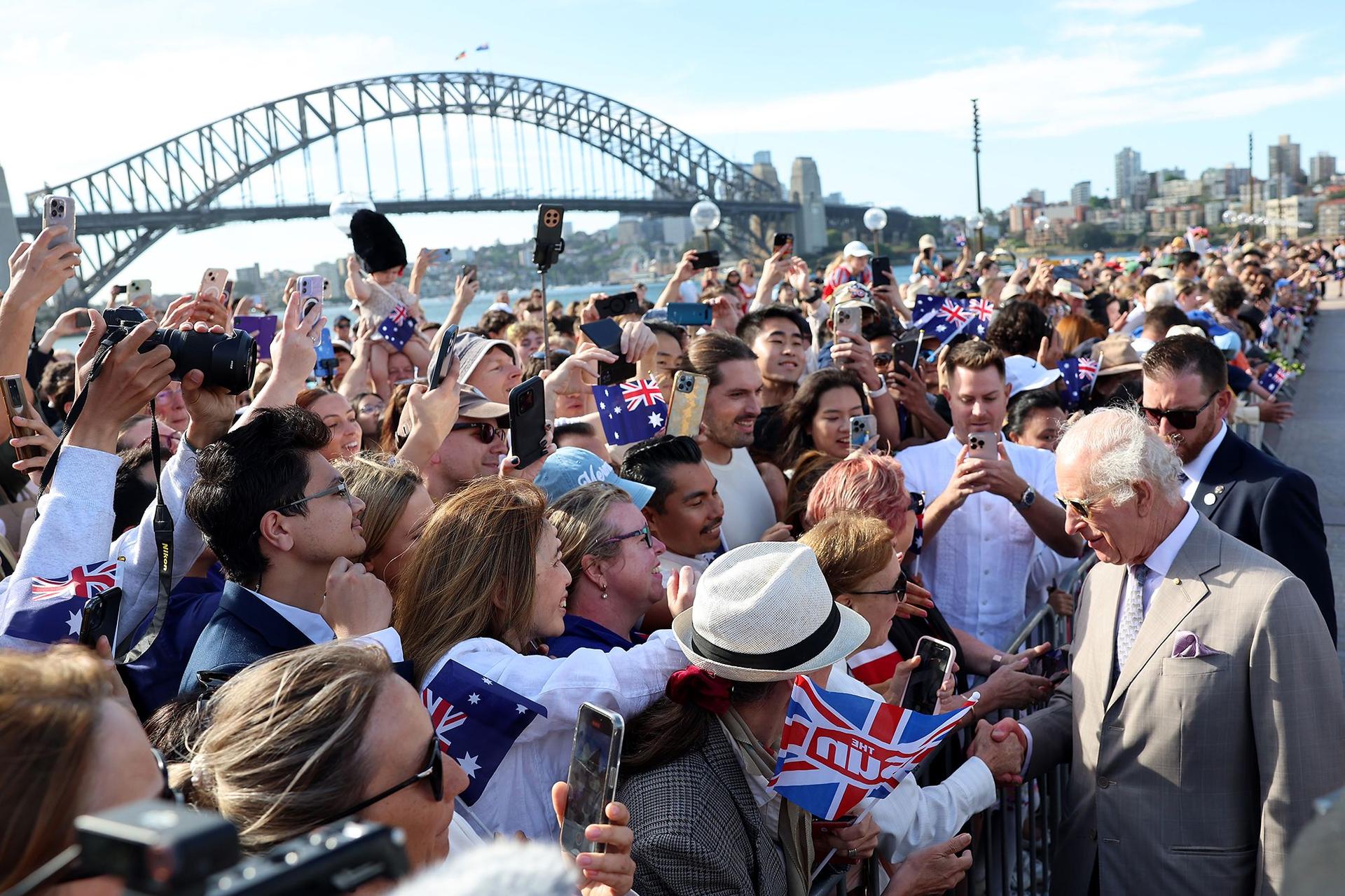 King Charles III greets spectators during a visit to the Sydney Opera House on Tuesday. The King's trip to Australia was his first as monarch. He is head of state of 14 realms in addition to the United Kingdom.   