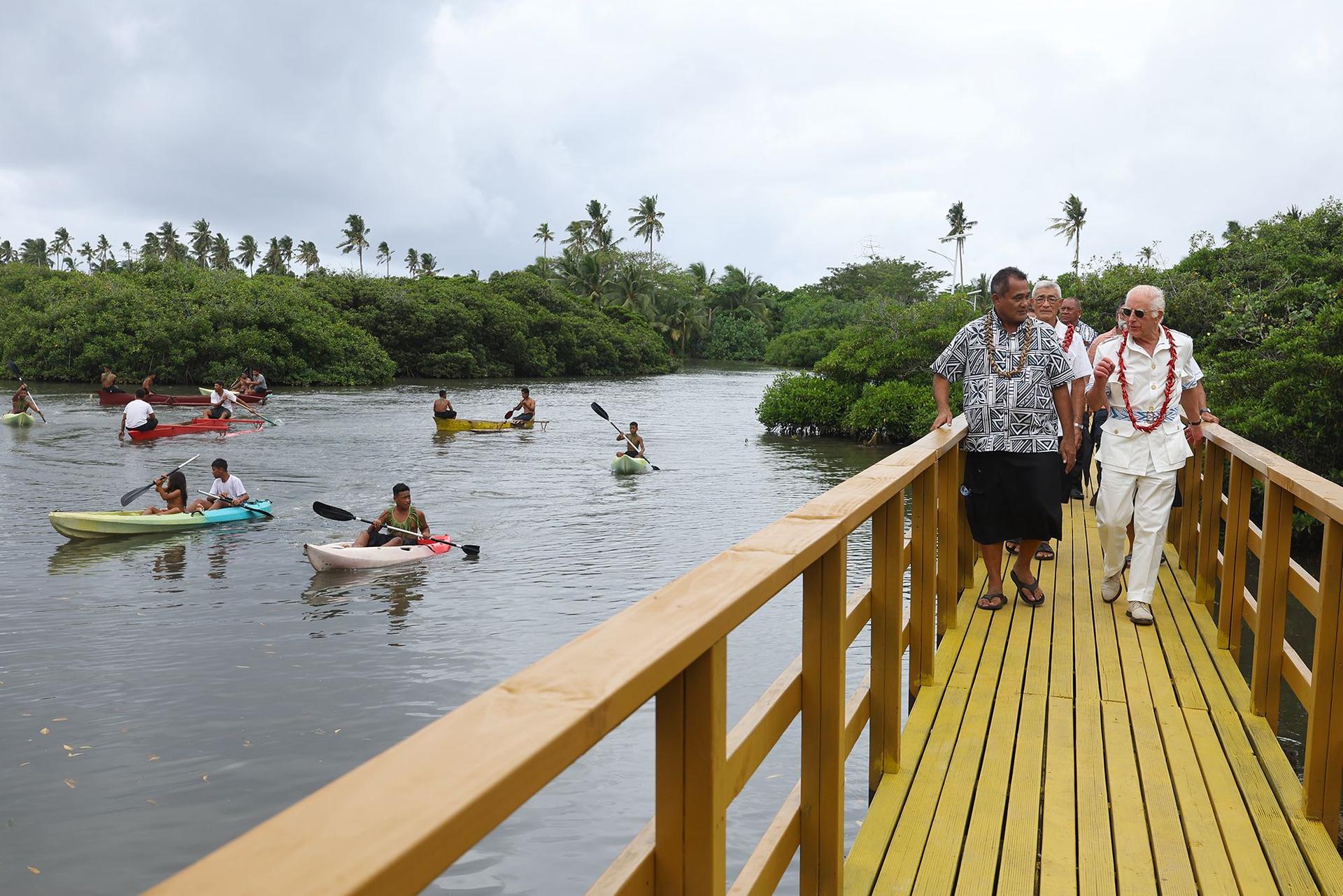 King Charles III and politician Toeolesulusulu Cedric Schuster walk across a restored boardwalk as the British monarch visits the Mangrove Restoration Project on Thursday at Moata'a Village near the Samoan capital.