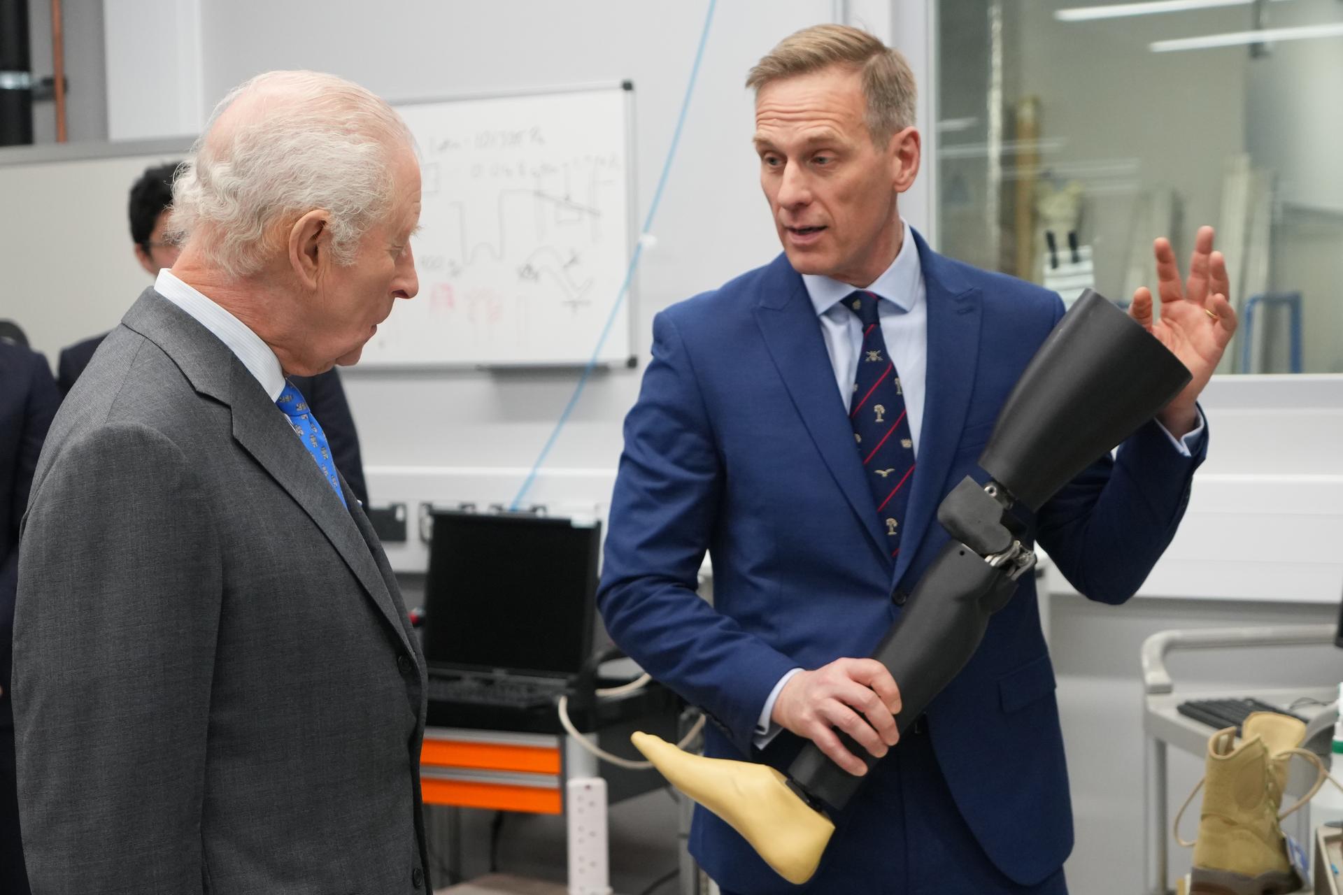 King Charles III is shown a prosthetic leg by Anthony Bull the director of the centre during a visit to Injury Studies at the Imperial College London's White City Campus.