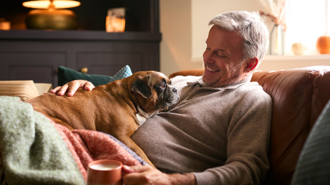 Man on couch with a dog on his lap